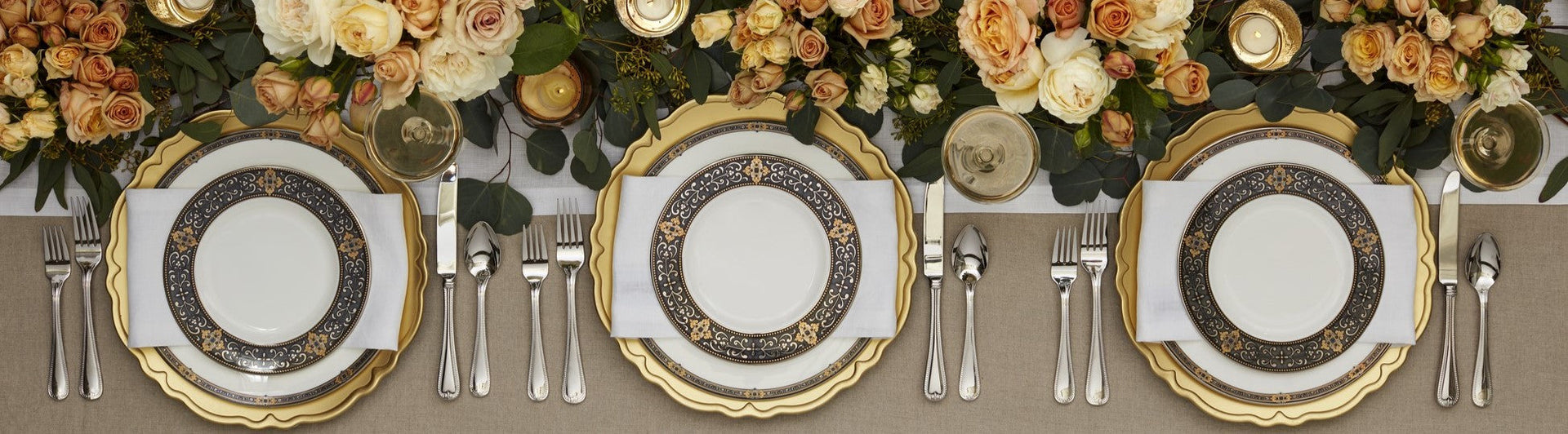 table with white plates with gold accents and florals