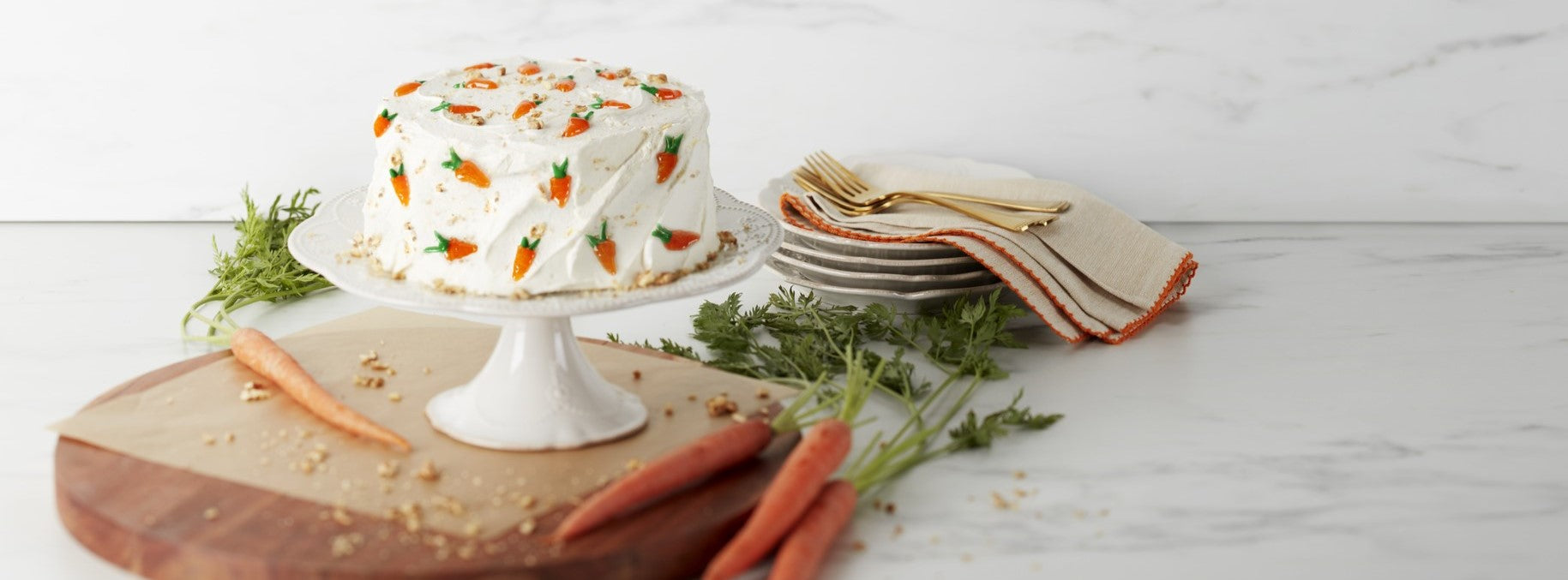 Carrot cake on stand with fresh carrots