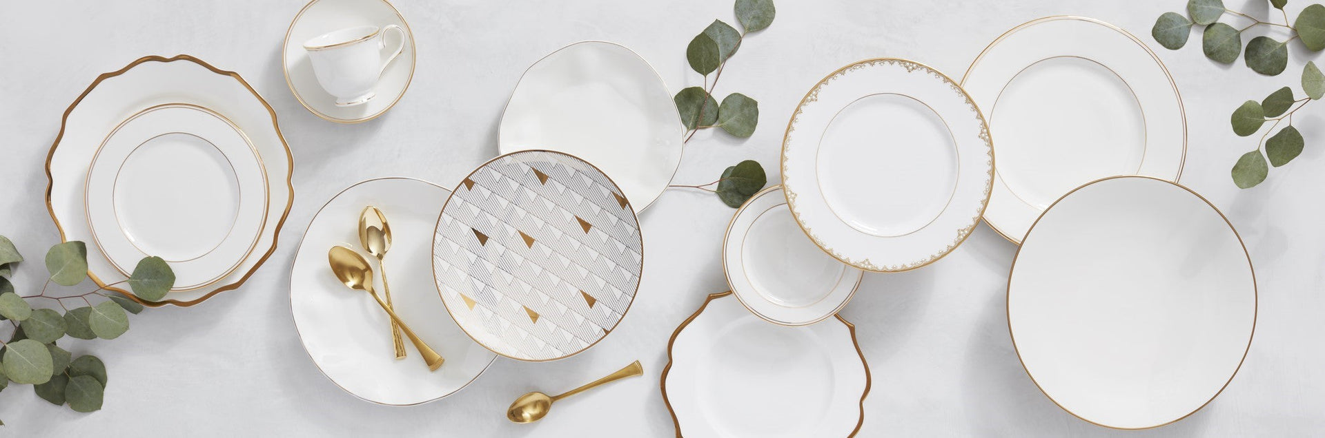 Elegant white and gold dinnerware with greenery