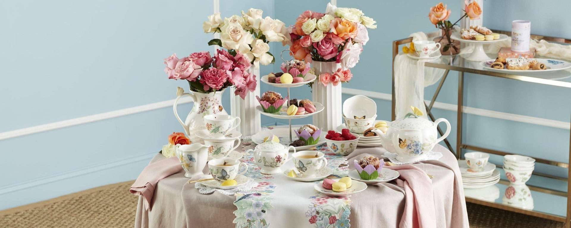 Elegant tea set with floral arrangements and pastries