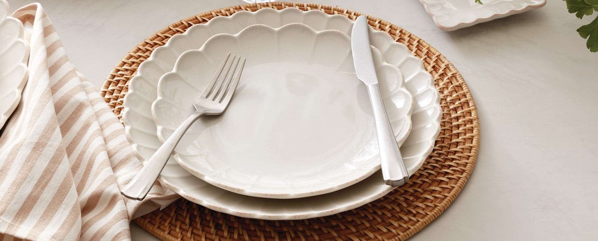 Scalloped plates on woven rattan placemat.