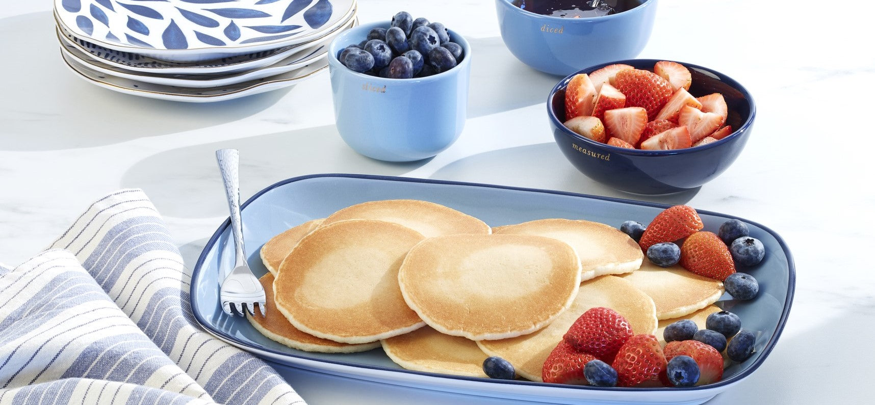 Pancakes served on a platter with fresh berries.