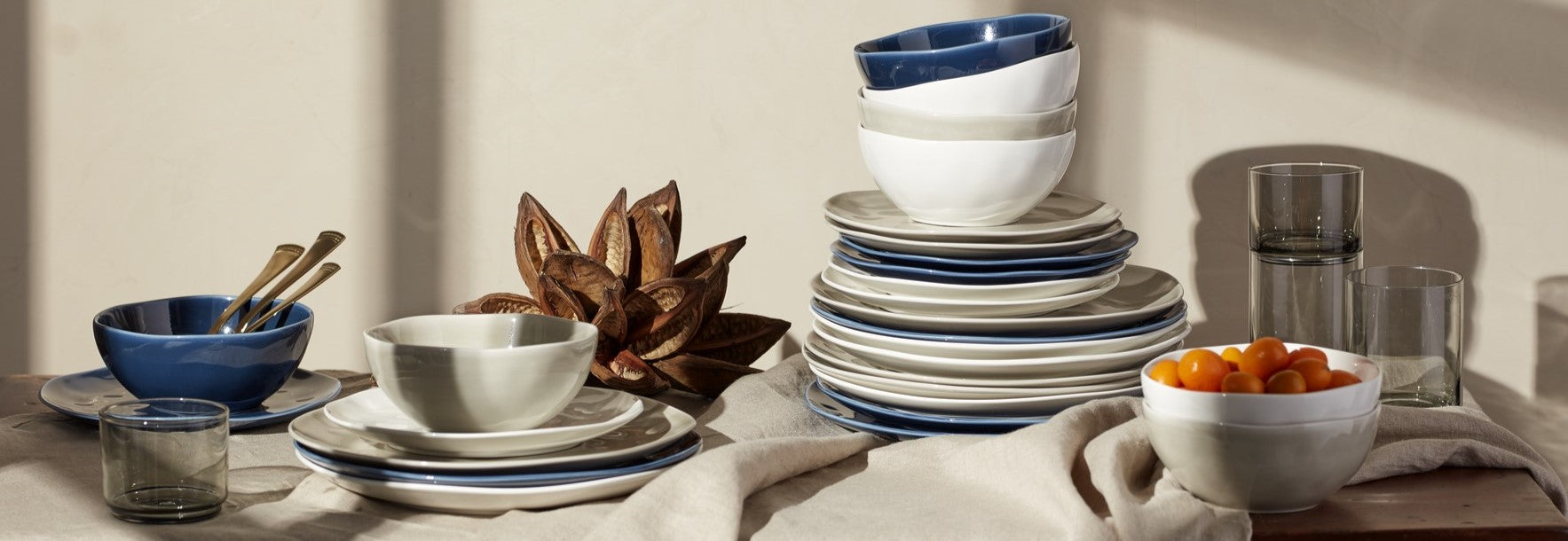 Stacked organic dinnerware in blue, white, and grey