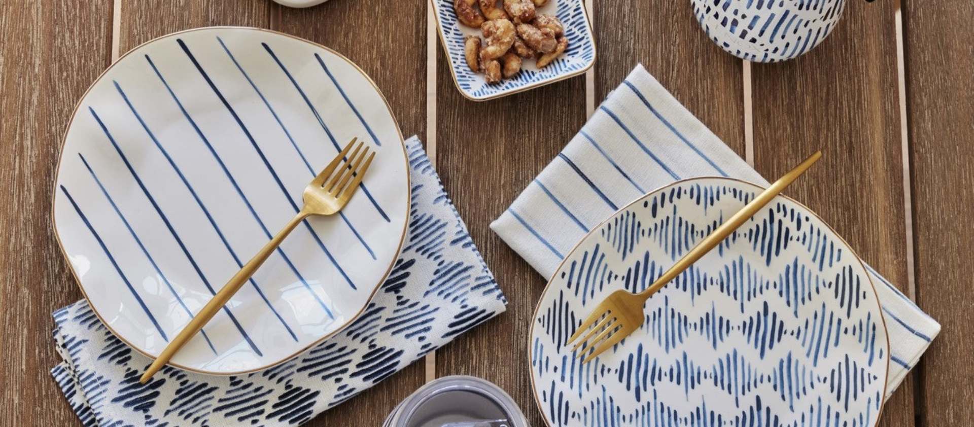 Blue-patterned plates and gold forks on wood