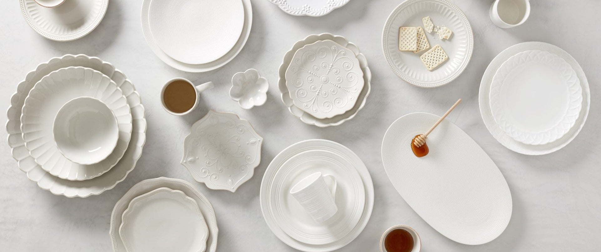 Assorted white ceramic dinnerware on marble