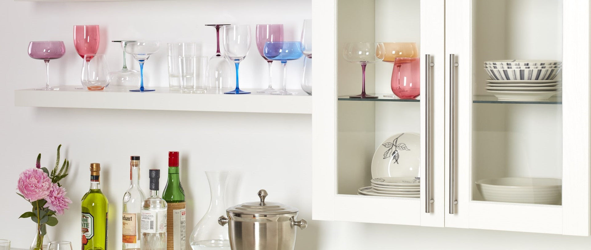 Colorful glassware and barware on white shelves