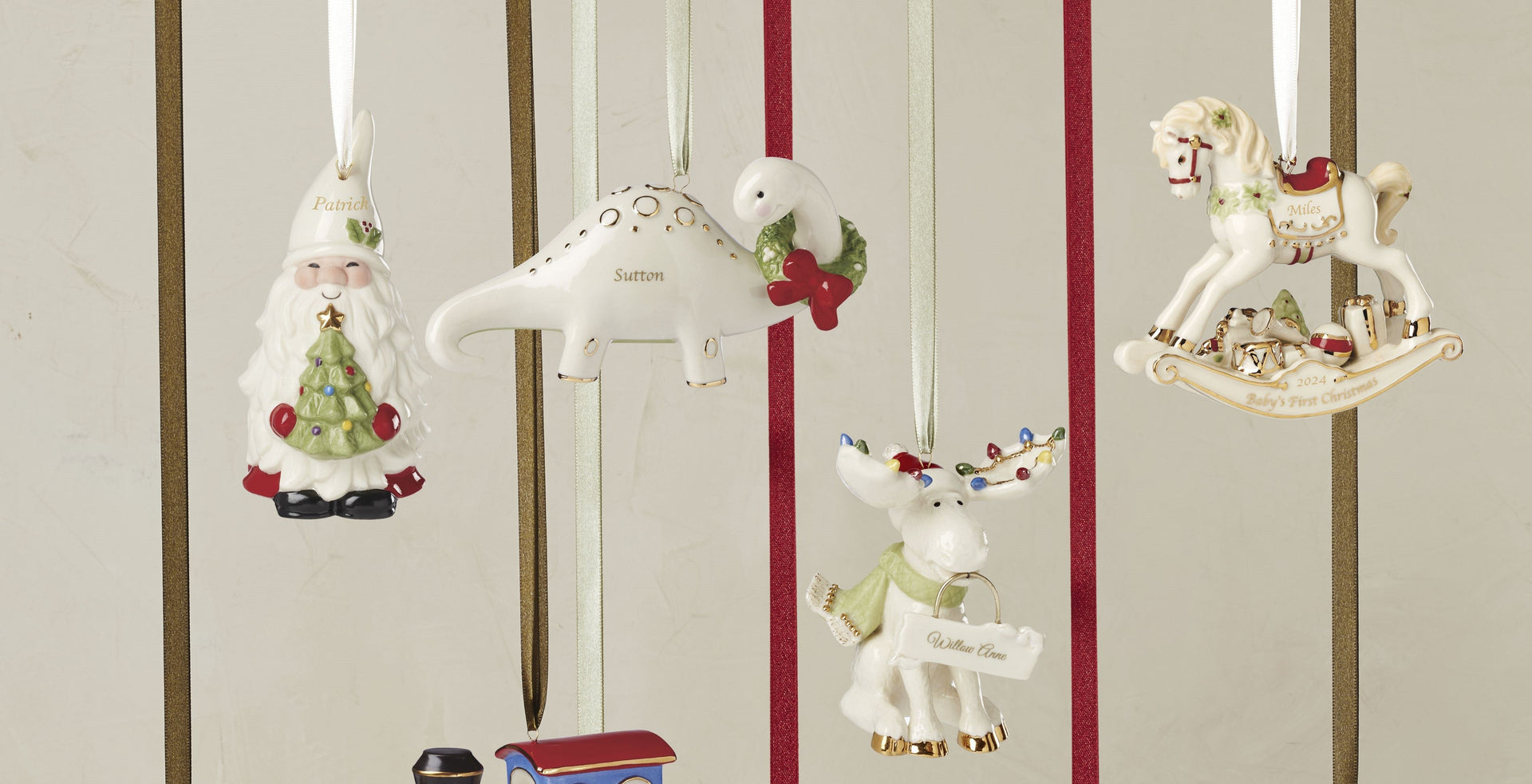 Personalized white ceramic holiday ornaments hanging on ribbons.