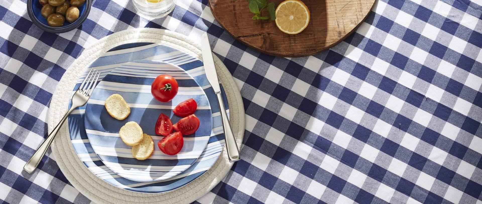 A striped plate with bread and tomatoes.