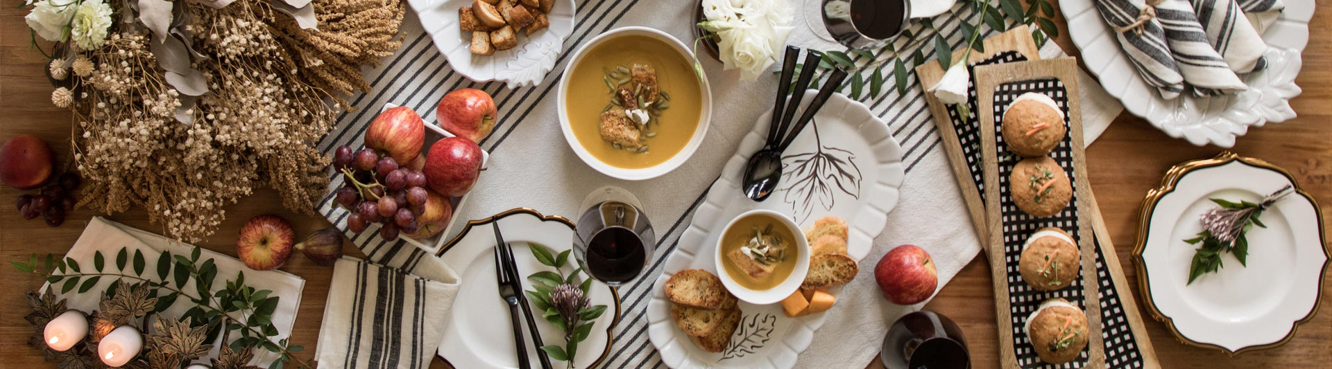 Dinner table with white dishes and autumnal foods