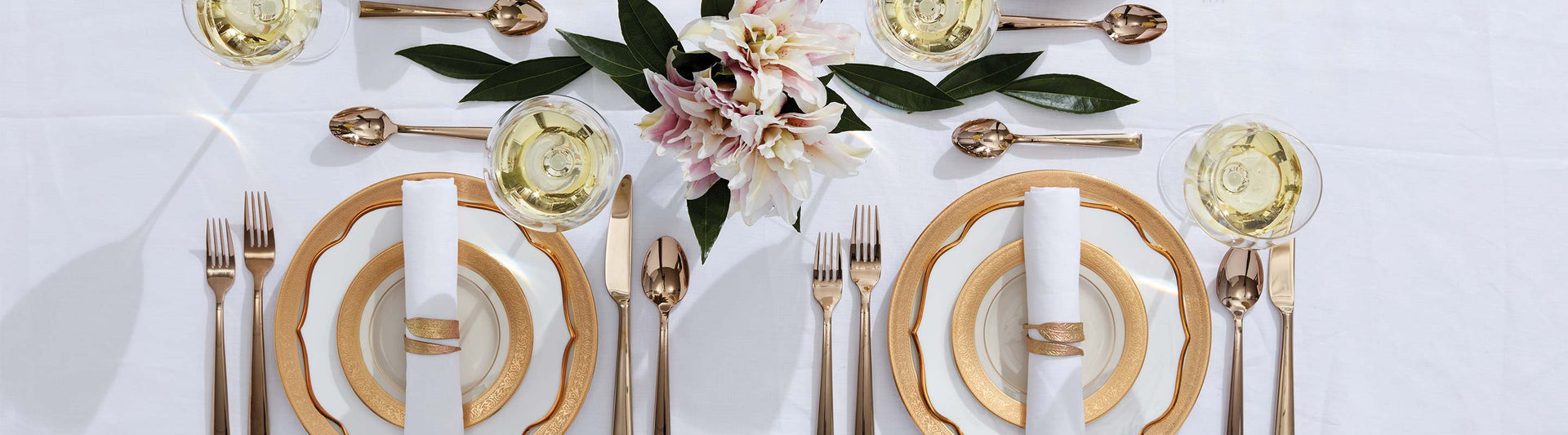 Formal table setting with gold and white dishes