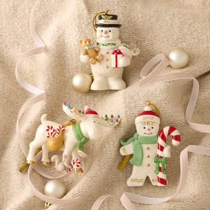 Set of Christmas ornaments including a snowman, reindeer, and another character on a beige background.