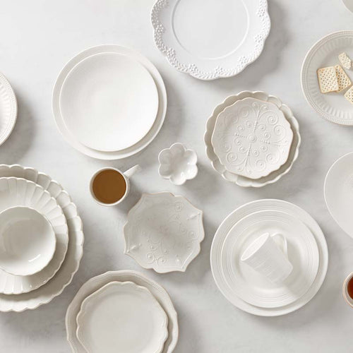 Collection of white ceramic dishes on a light gray background